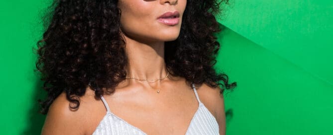 Woman with long black curly hair wearing Transitions 2 photochromic lenses in black wire frame at Maple Grove Eye Doctors
