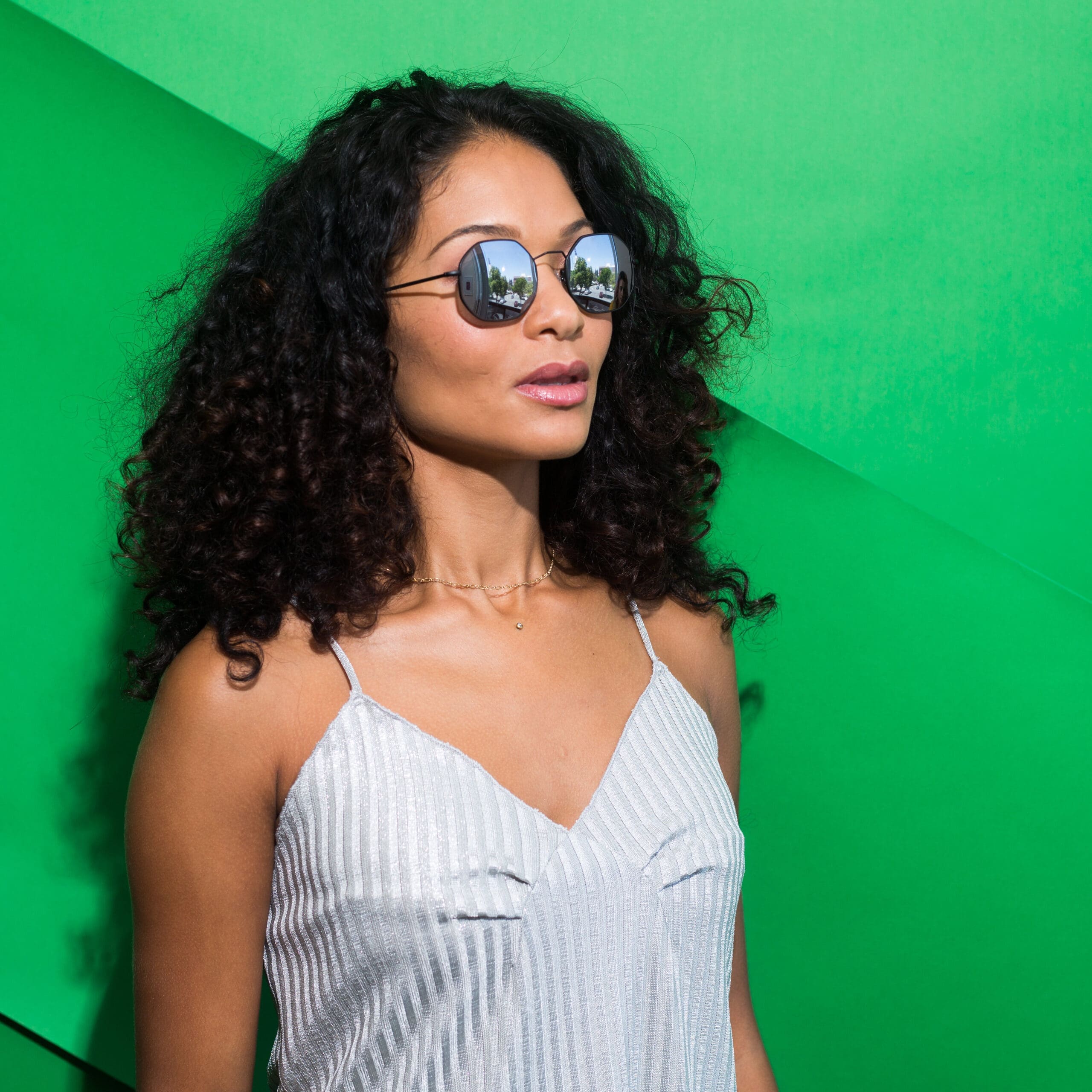 Woman with long black curly hair wearing Transitions 2 photochromic lenses in black wire frame at Maple Grove Eye Doctors