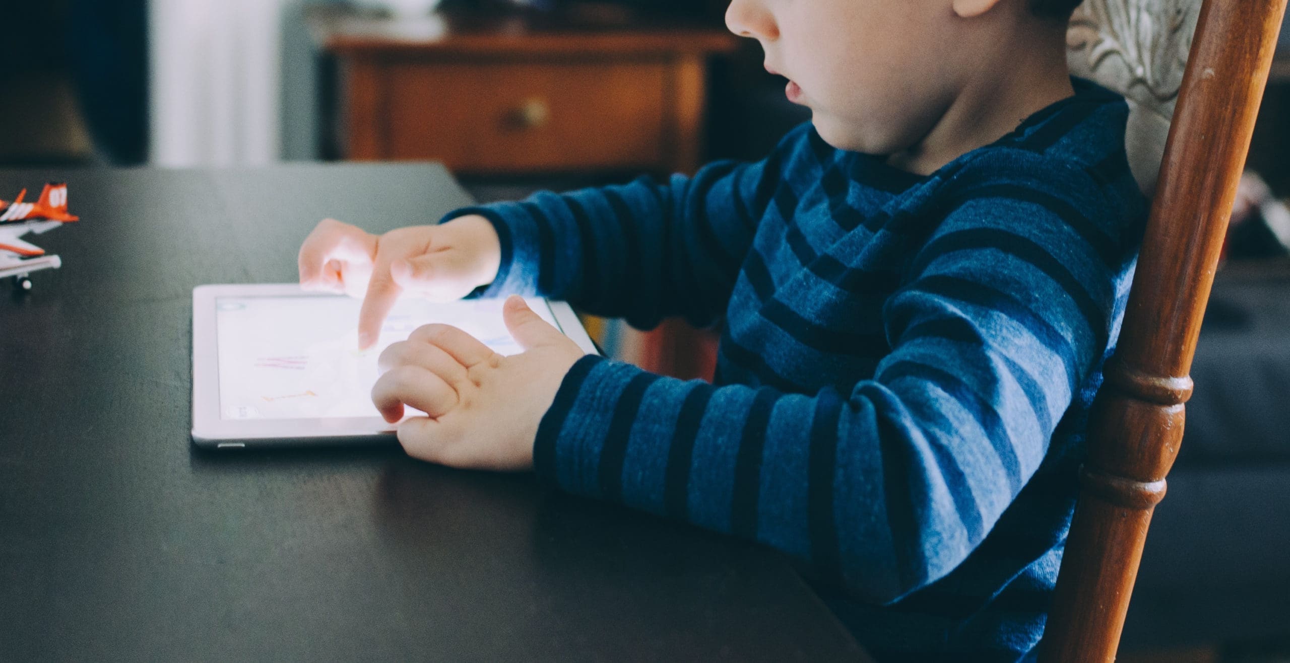 Kid Playing with a Tablet Maple Grove Eye Doctors at Pearle Vision