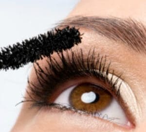 Woman applying mascara with brush while wearing Contacts Maple Grove Eye Doctors at Pearle Vision